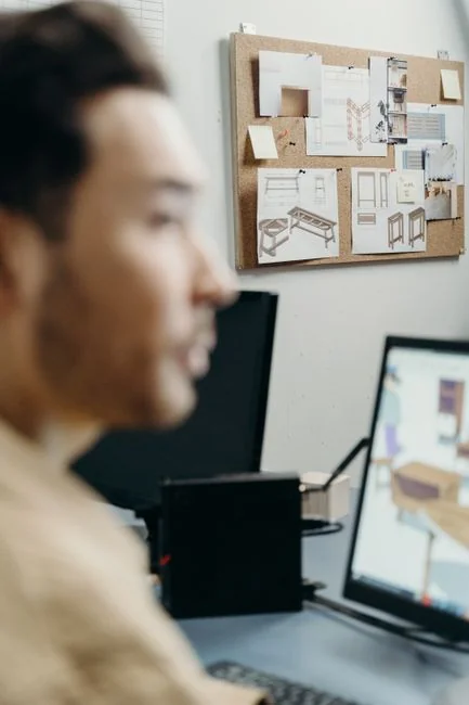 A website wireframe on a macbook screen on an office desk.